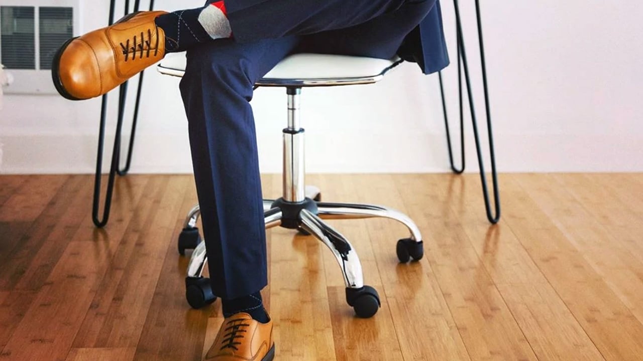 Man sitting in an office chair with carets shoes on his feet