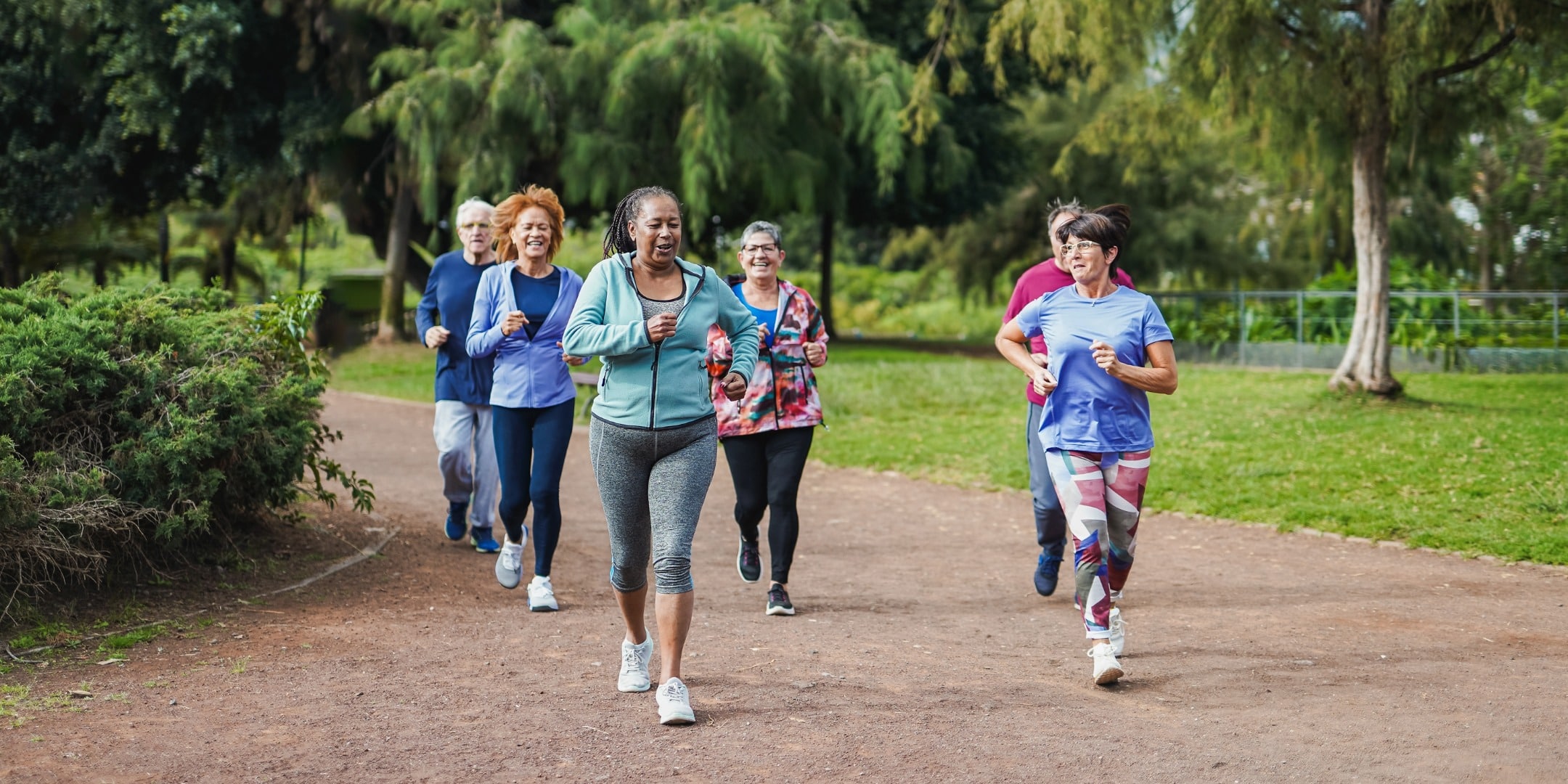 seniors chirunning in a park on a dirt path